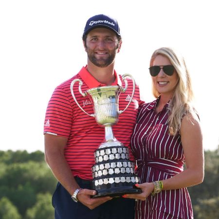 Jon holding his golf trophy with college sweetheart Kelly